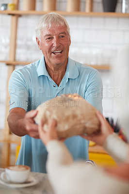 Buy stock photo Shot of a happy senior man serving a customer in a bakery