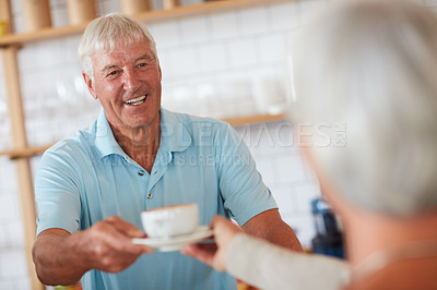 Buy stock photo Shot of a happy senior man bing served a cup of coffee in a cafe