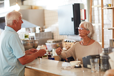 Buy stock photo Shot of a senior woman serving a customer a cup of coffee in a cafe