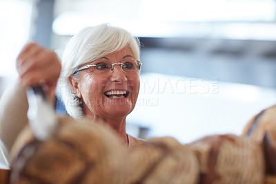 Buy stock photo Shot of a happy senior woman working in a bakery