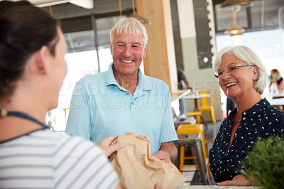 Buy stock photo Cropped shot of a senior couple being served by a waitress