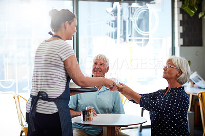 Buy stock photo Cropped shot of a senior couple being served by a waitress