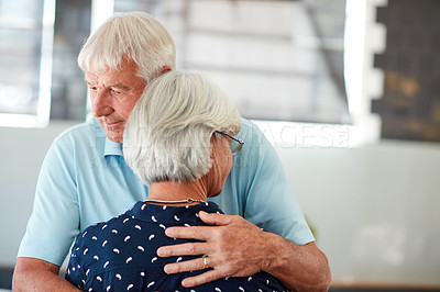 Buy stock photo Shot of a senior man embracing his wife