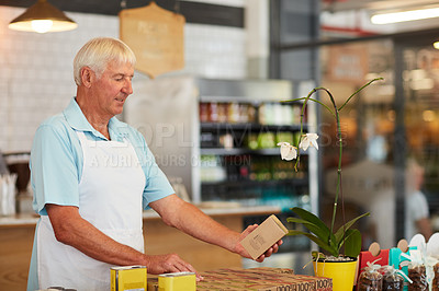 Buy stock photo Shot of a senior man doing inventory in his store