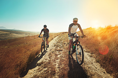 Buy stock photo Shot of two cyclists out cycling in the countryside