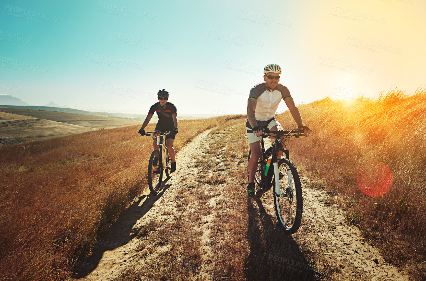 Buy stock photo Shot of two cyclists out cycling in the countryside