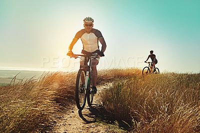 Buy stock photo Shot of two cyclists out cycling in the countryside