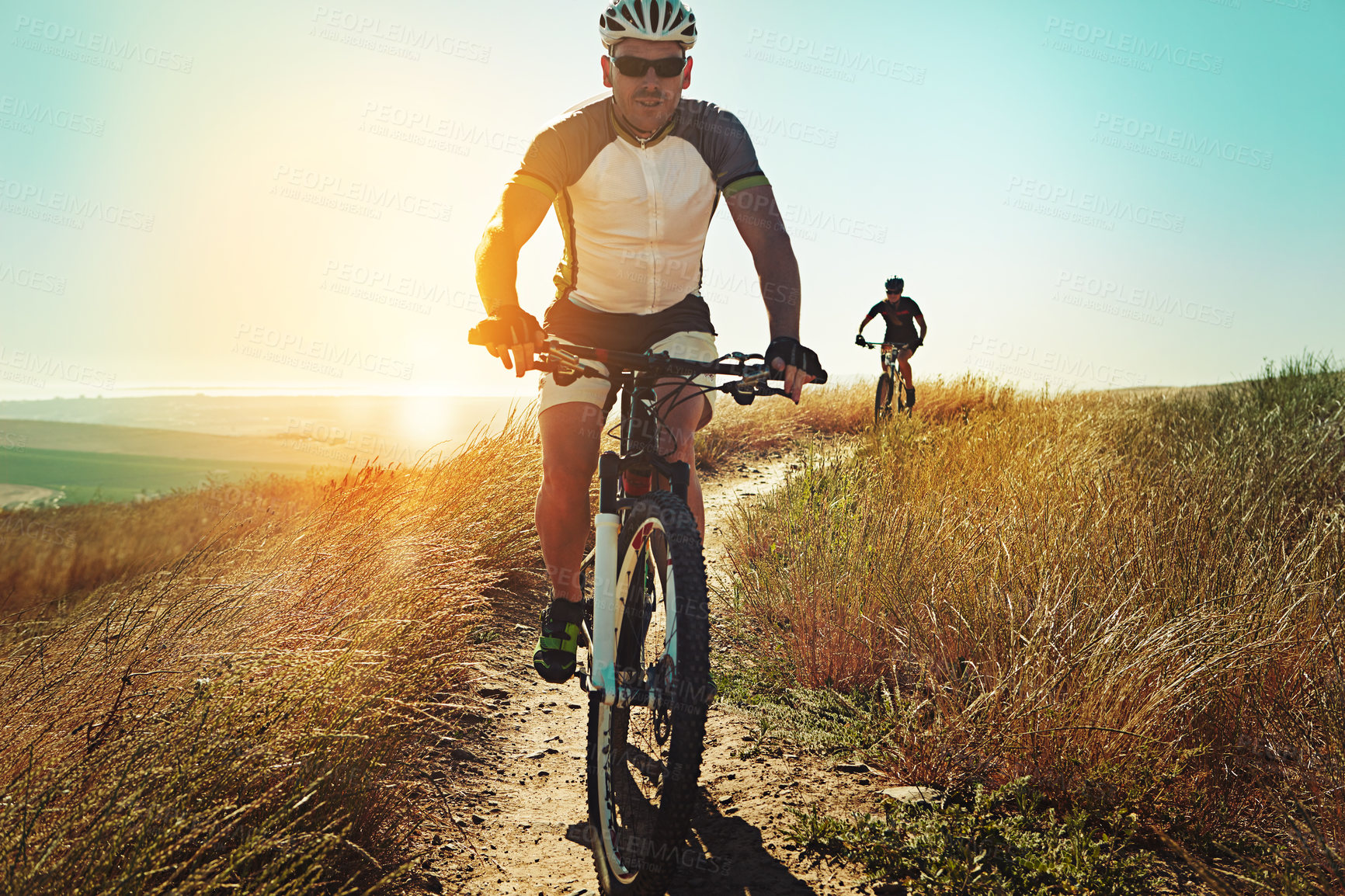 Buy stock photo Shot of two cyclists out cycling in the countryside