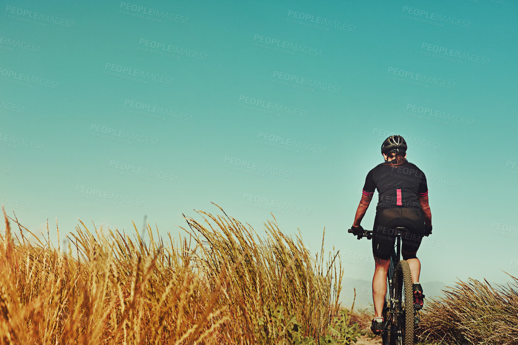 Buy stock photo Countryside, bike and person with fitness, back and travel with adventure, practice and wellness. Cyclist, outdoor or bicycle for cardio training, low angle or helmet for safety, hobby or challenge