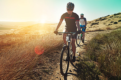 Buy stock photo Shot of two cyclists out cycling in the countryside