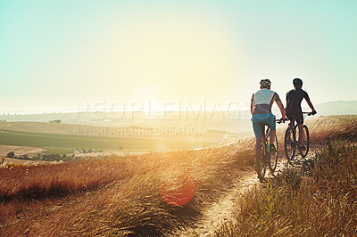 Buy stock photo Shot of two cyclists out cycling in the countryside