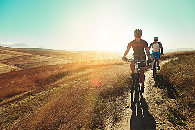 Buy stock photo Shot of two cyclists out cycling in the countryside