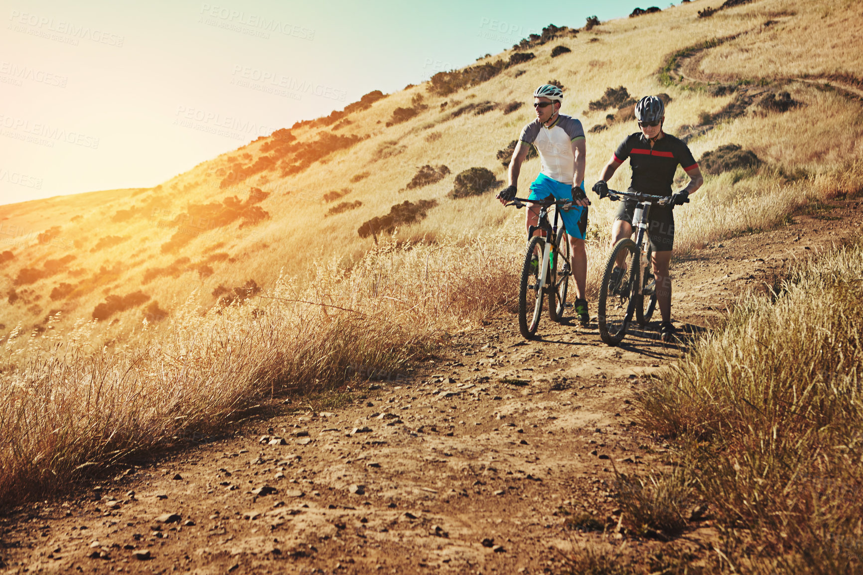 Buy stock photo Shot of two cyclists out cycling in the countryside