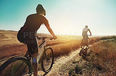 Buy stock photo Shot of two cyclists out cycling in the countryside