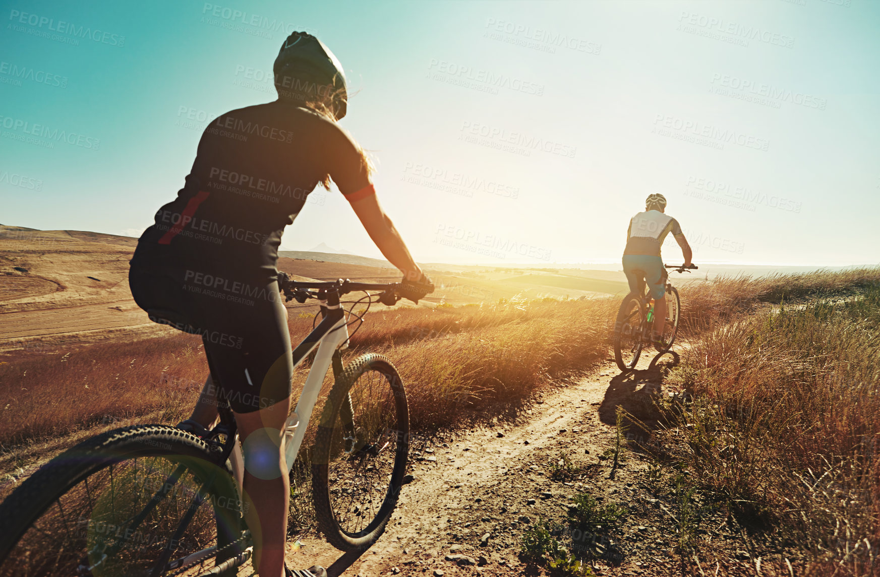 Buy stock photo Shot of two cyclists out cycling in the countryside