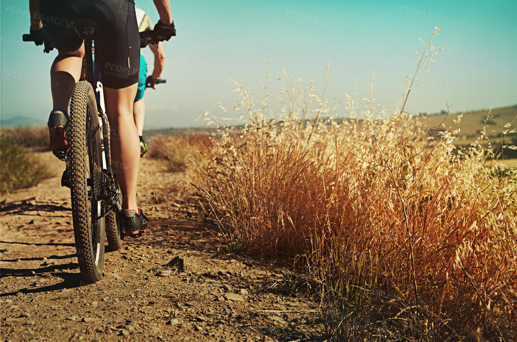 Buy stock photo Shot of two cyclists out cycling in the countryside