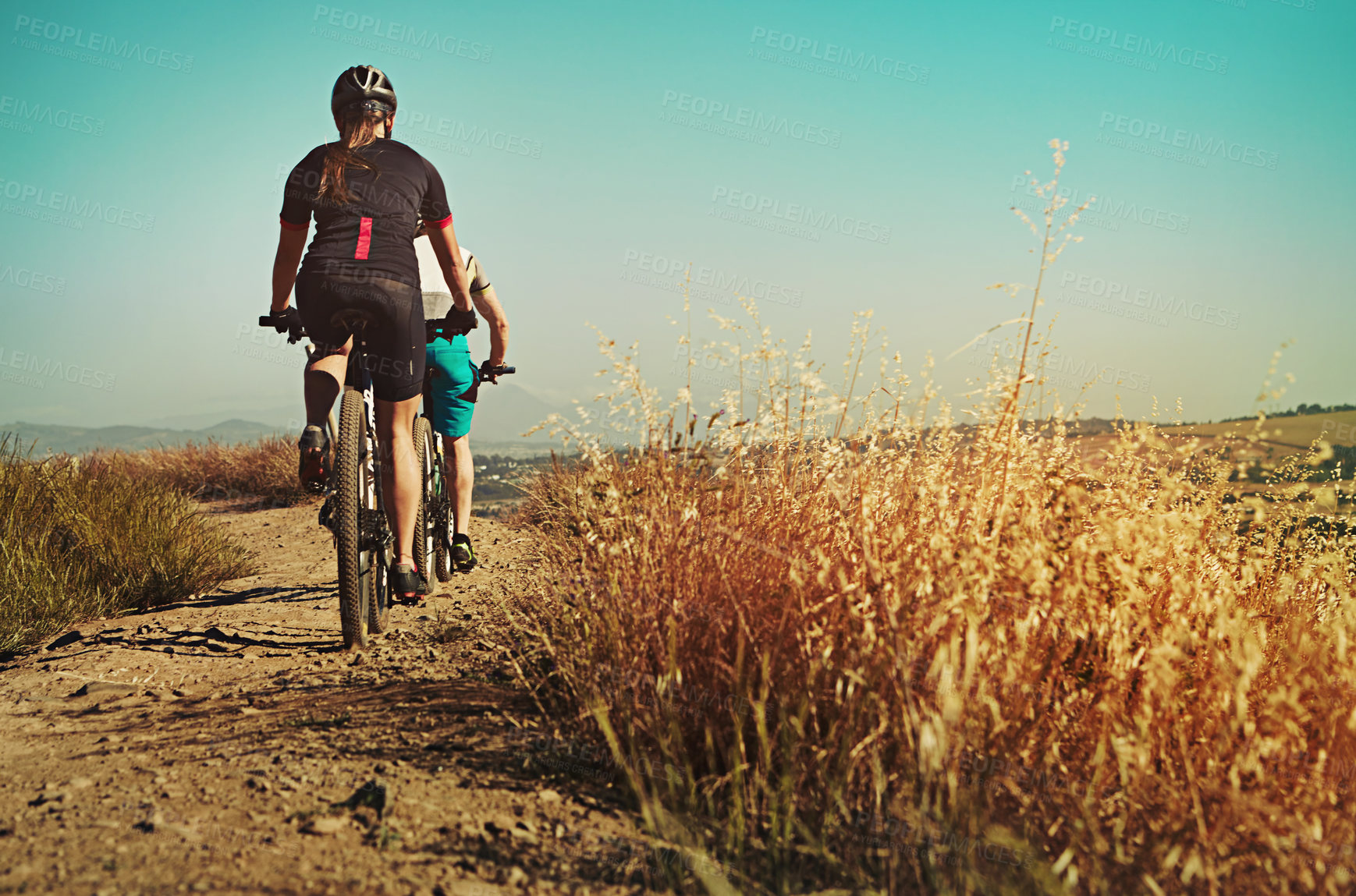 Buy stock photo Shot of two cyclists out cycling in the countryside