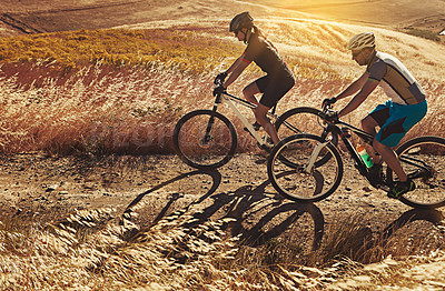 Buy stock photo Shot of two cyclists out cycling in the countryside