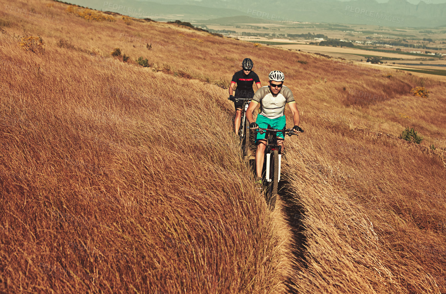 Buy stock photo Shot of two cyclists out cycling in the countryside