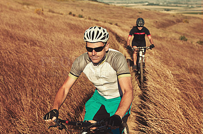 Buy stock photo Shot of two cyclists out cycling in the countryside