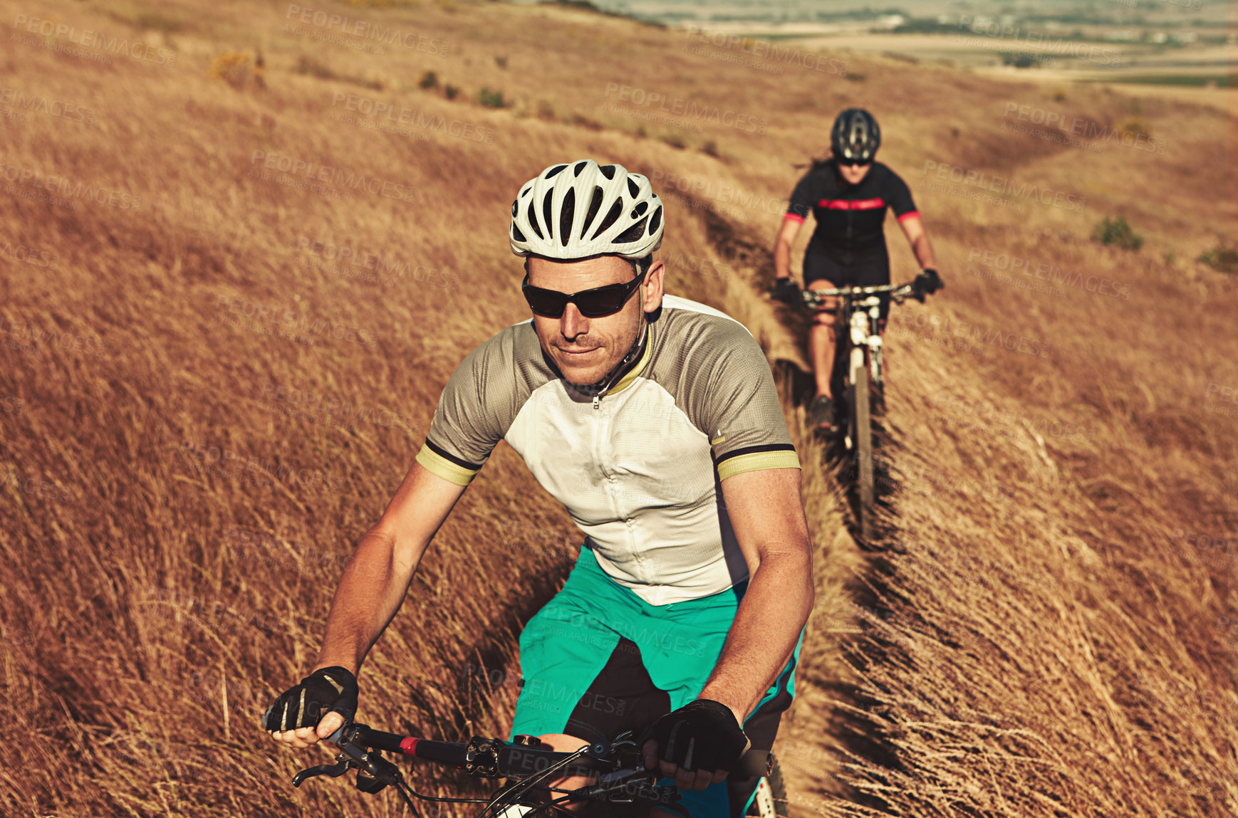 Buy stock photo Shot of two cyclists out cycling in the countryside