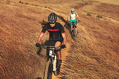 Buy stock photo Shot of two cyclists out cycling in the countryside