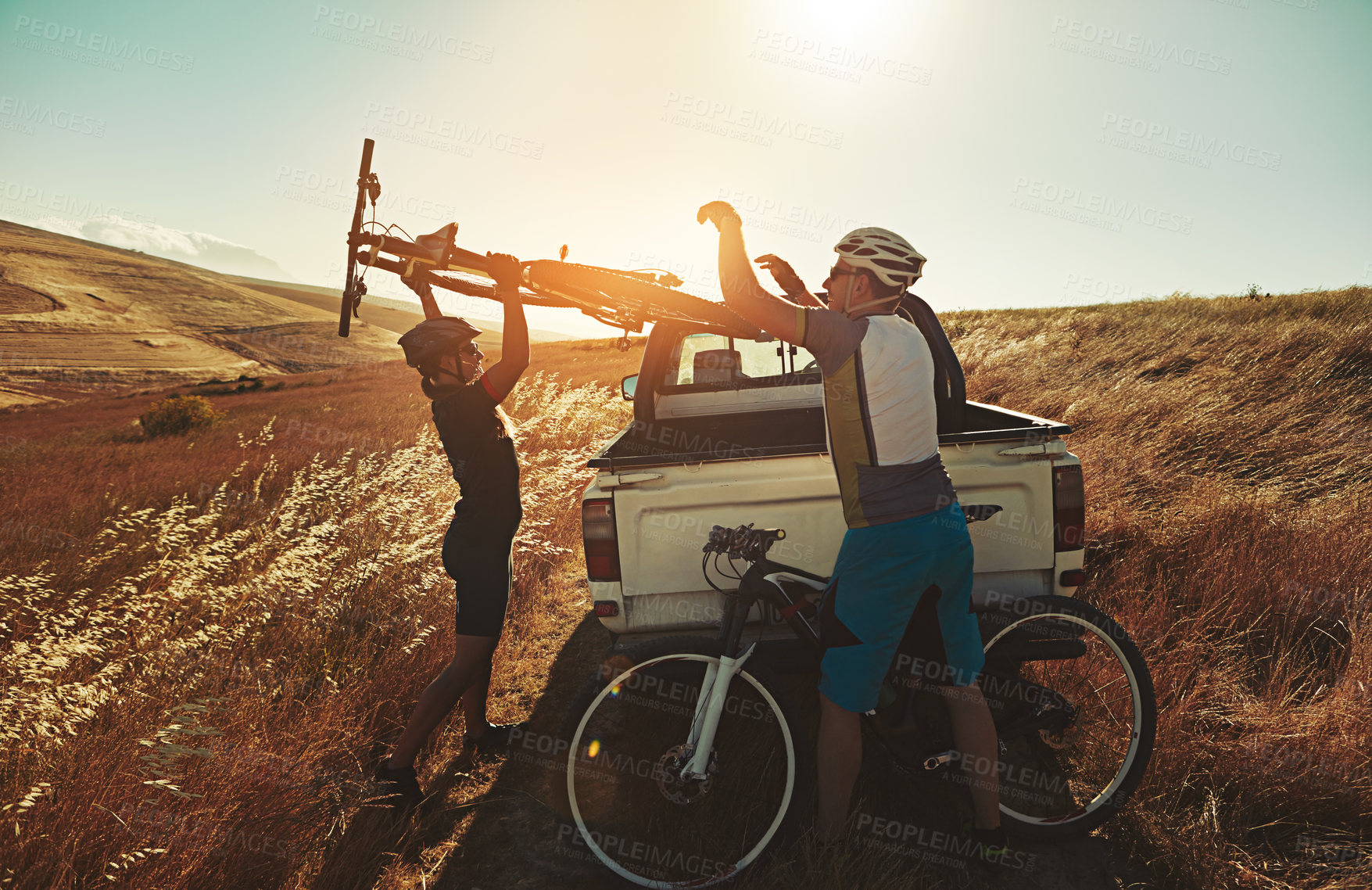 Buy stock photo Shot of a pair of adventurous mountain bikers getting ready to explore a new trail together