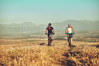 Buy stock photo Shot of two cyclists out cycling in the countryside