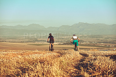 Buy stock photo Shot of two cyclists out cycling in the countryside