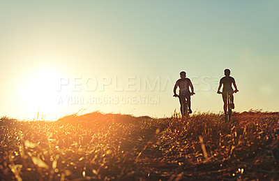 Buy stock photo Sunset, men and friends on bicycle together with grass, exercise and adventure trail in nature. Cycling race, fitness and people with mountain bike in evening for outdoor workout, energy and health