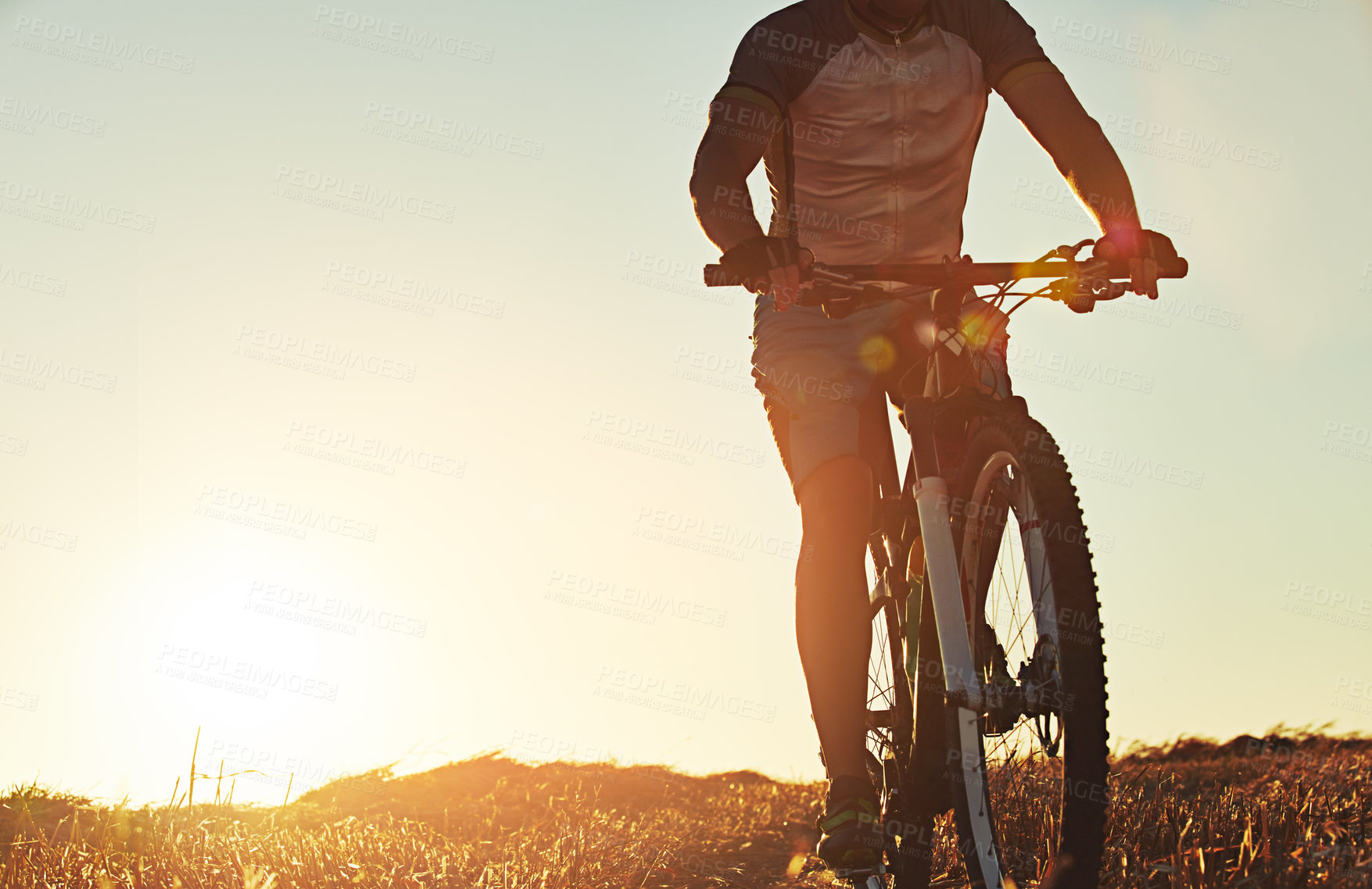 Buy stock photo Shot of an unidentifiable mountain biker out on a trail on a sunny day