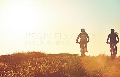 Buy stock photo Sunset sky, people and team in bicycle race with grass, exercise and adventure trail in nature together. Cycling, fitness and friends with mountain bike in evening for outdoor workout, sun and mockup