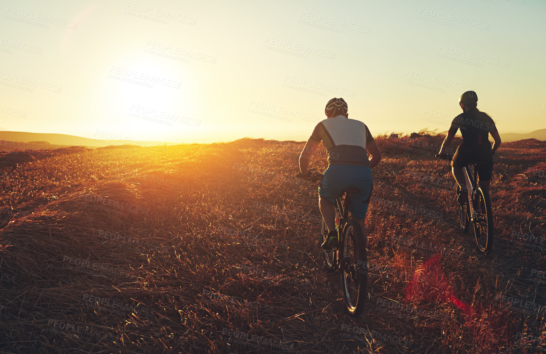 Buy stock photo Sunset, sky and friends in bicycle race with exercise, countryside and adventure trail in nature together. Cycling, fitness and people with mountain bike in evening for outdoor workout from back