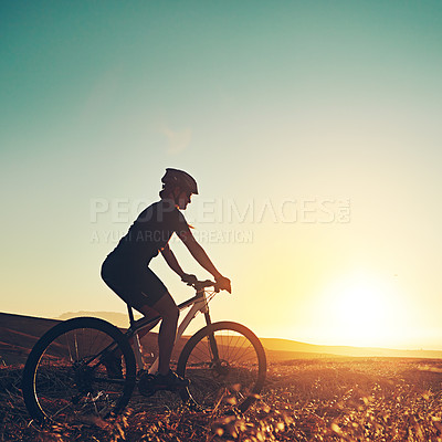 Buy stock photo Shot of an adventurous mountain biker out for a ride in the countryside