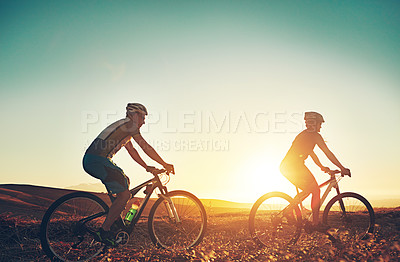 Buy stock photo Sunset, sky and people on bicycle with adventure, race and exercise trail in nature together. Cycling, fitness and friends with mountain bike in evening for outdoor workout, blue sky and grass path