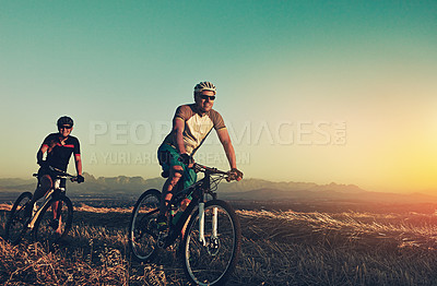 Buy stock photo Sunset, mountain and people in bicycle race with helmet, exercise and adventure trail in nature together. Cycling, fitness and friends on bike in evening for outdoor workout, health and wellness