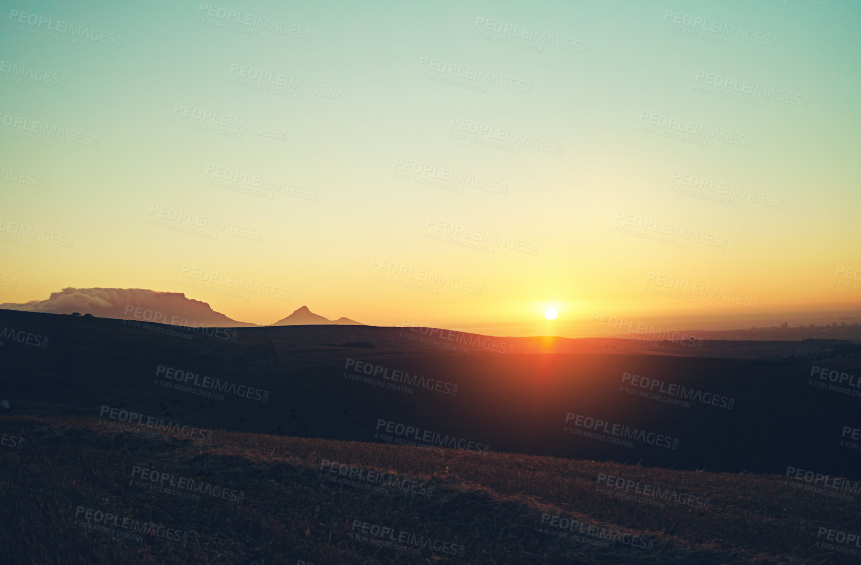 Buy stock photo Shot of the sun setting over a beautiful rural landscape