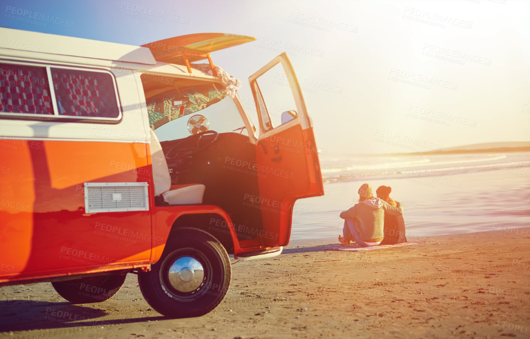 Buy stock photo Shot of a couple admiring the view on the beach while out on a road trip