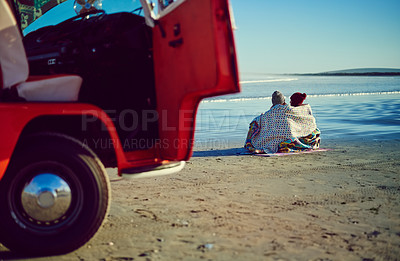Buy stock photo Shot of a couple admiring the view on the beach while out on a road trip