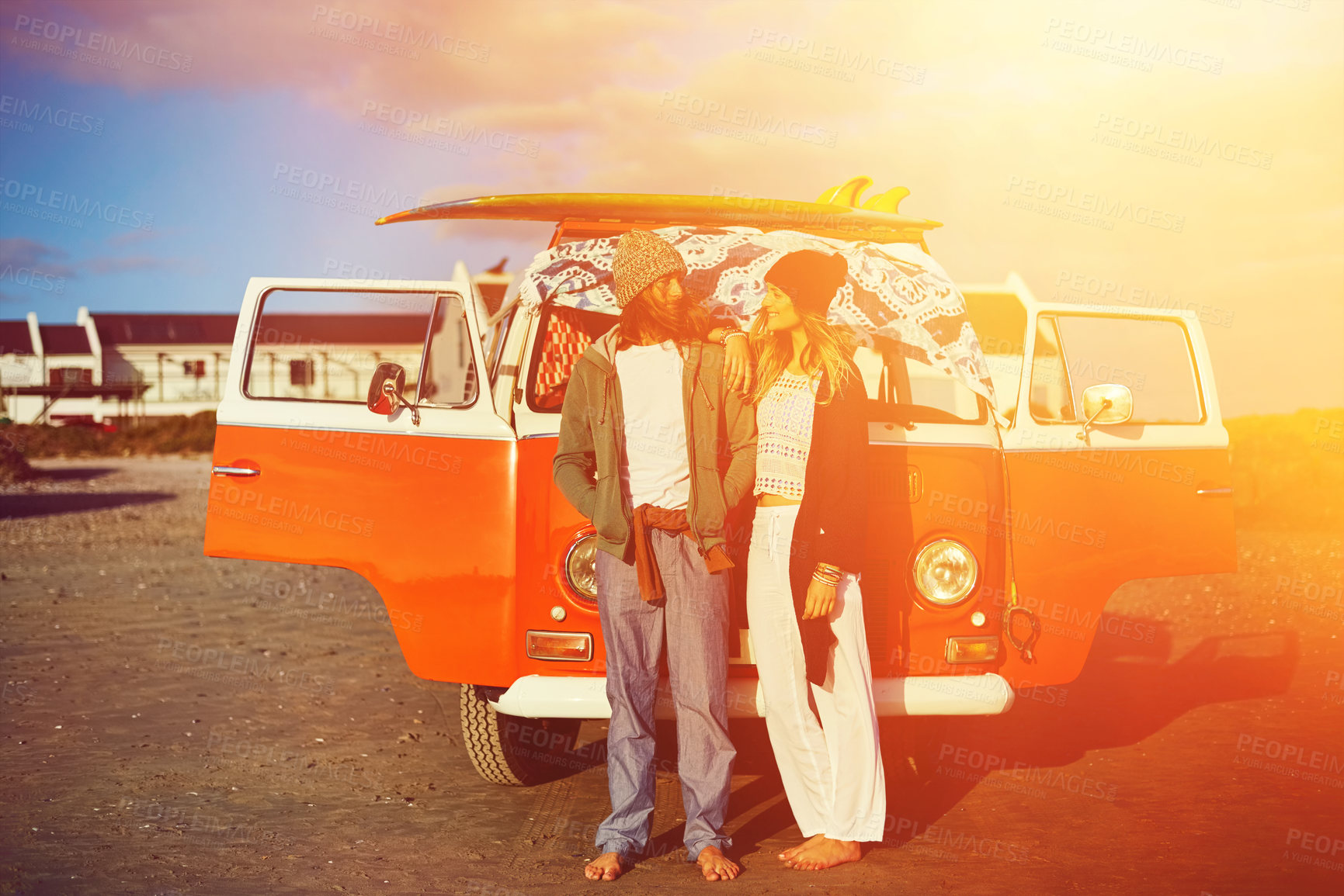 Buy stock photo Shot of an adventurous couple standing in front of their mini van