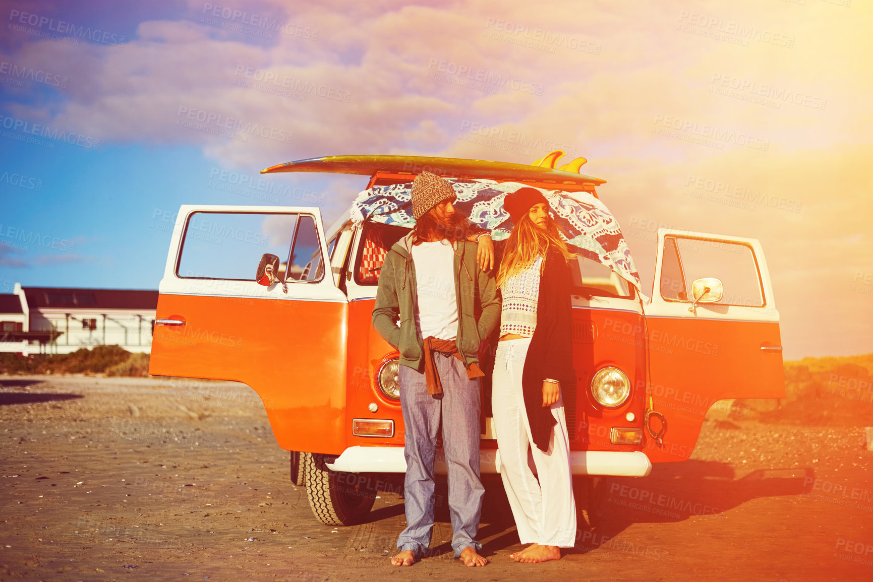 Buy stock photo Shot of an adventurous couple standing in front of their mini van