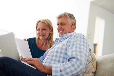 Buy stock photo Cropped shot of a mature couple going through their paperwork together at home