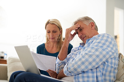 Buy stock photo Cropped shot of a mature couple looking stressed out while doing their budget at home