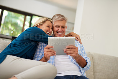 Buy stock photo Cropped shot of a mature couple using a digital tablet together at home