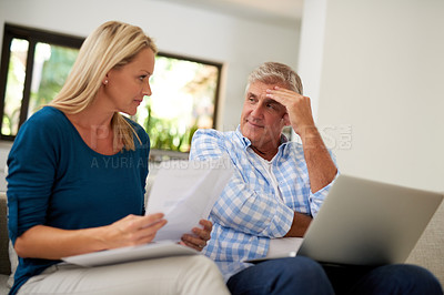 Buy stock photo Cropped shot of a mature couple looking stressed out while doing their budget at home