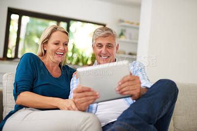 Buy stock photo Cropped shot of a mature couple using a digital tablet together at home