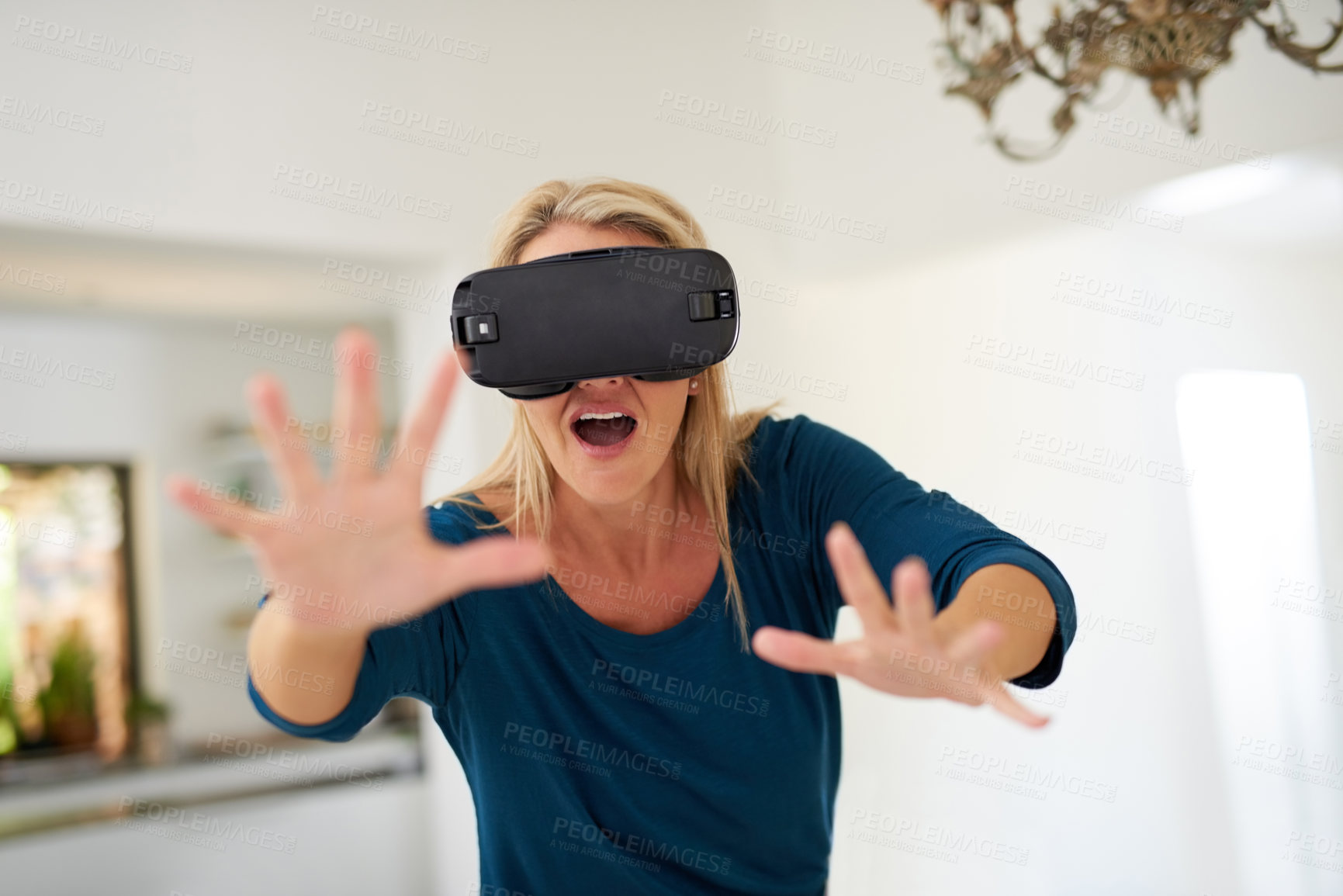 Buy stock photo Cropped shot of a mature woman wearing a VR headset at home
