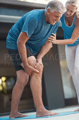 Buy stock photo Shot of a mature man grabbing his leg in pain after an intense workout with his wife