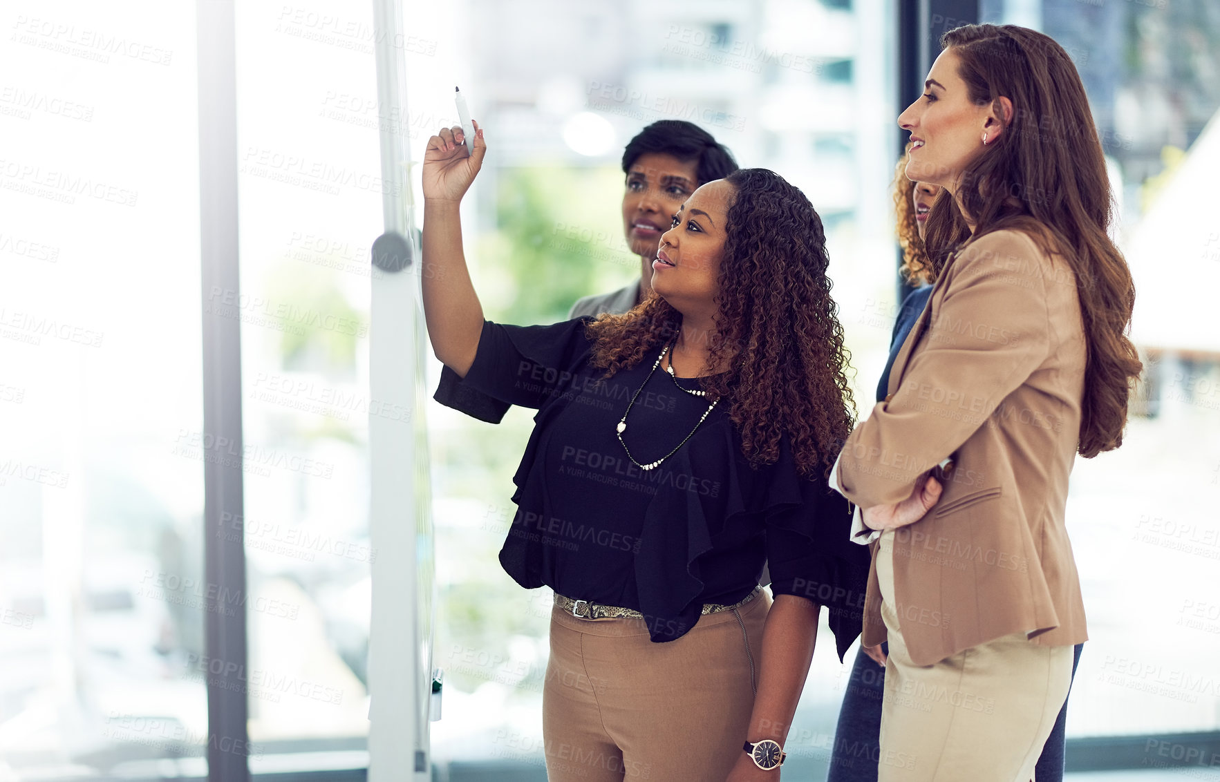 Buy stock photo Cropped shot of a group of businesswomen working on a whiteboard in the boardroom