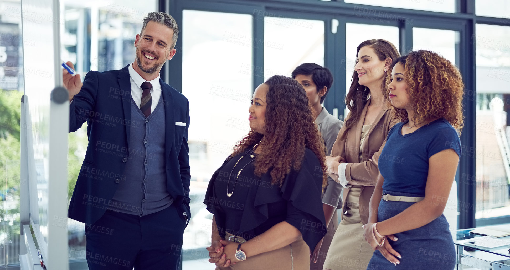 Buy stock photo Cropped shot of a group of businesspeople working on a whiteboard in the boardroom